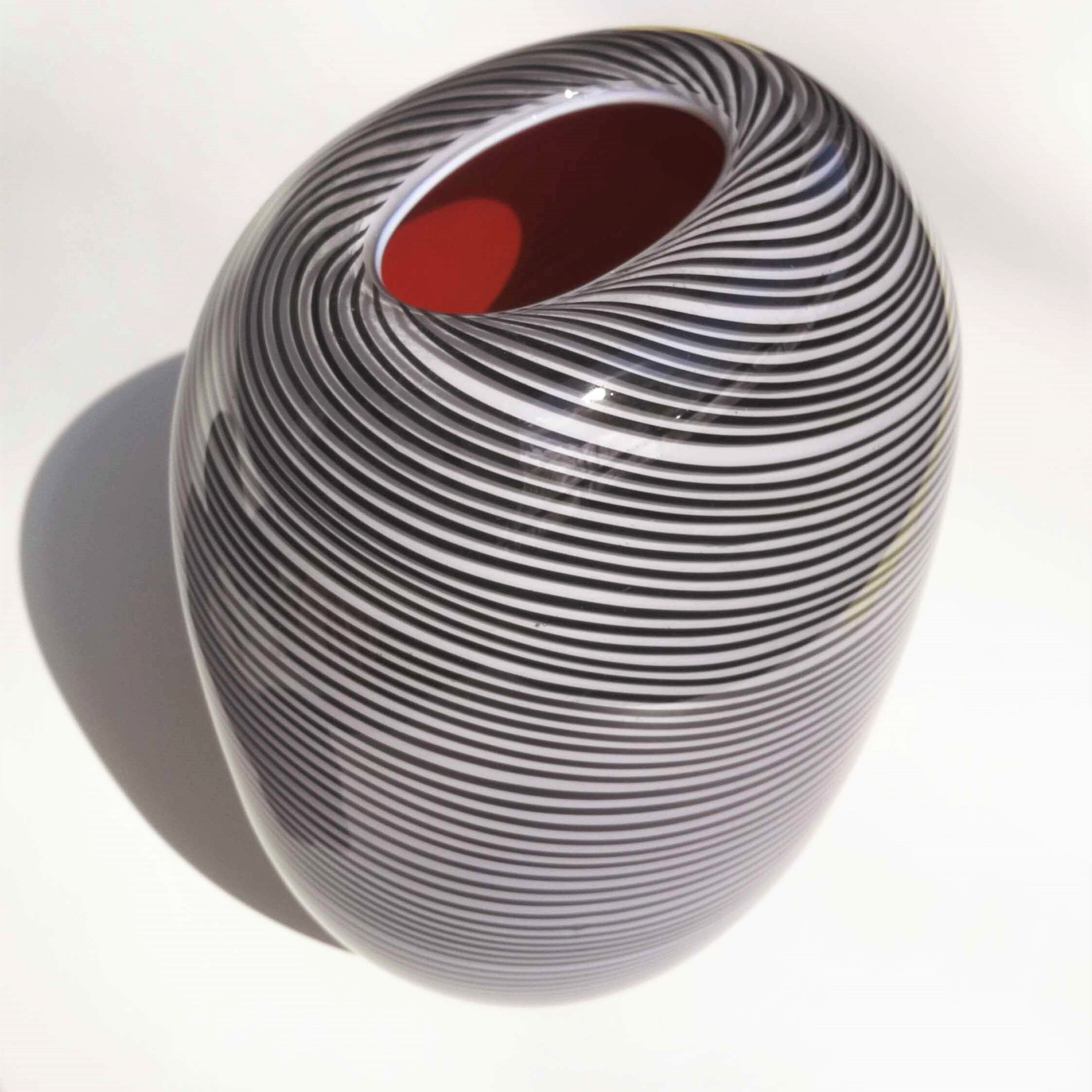 Lasinpuhallus tekniikalla valmistettu mustanharmaa uniikkilasi maljakko nimeltään Hiillos, jossa on punainen sisus. Koristelu on tehty filigraanitekniikalla. Heikki Jylhä-Vuorio.