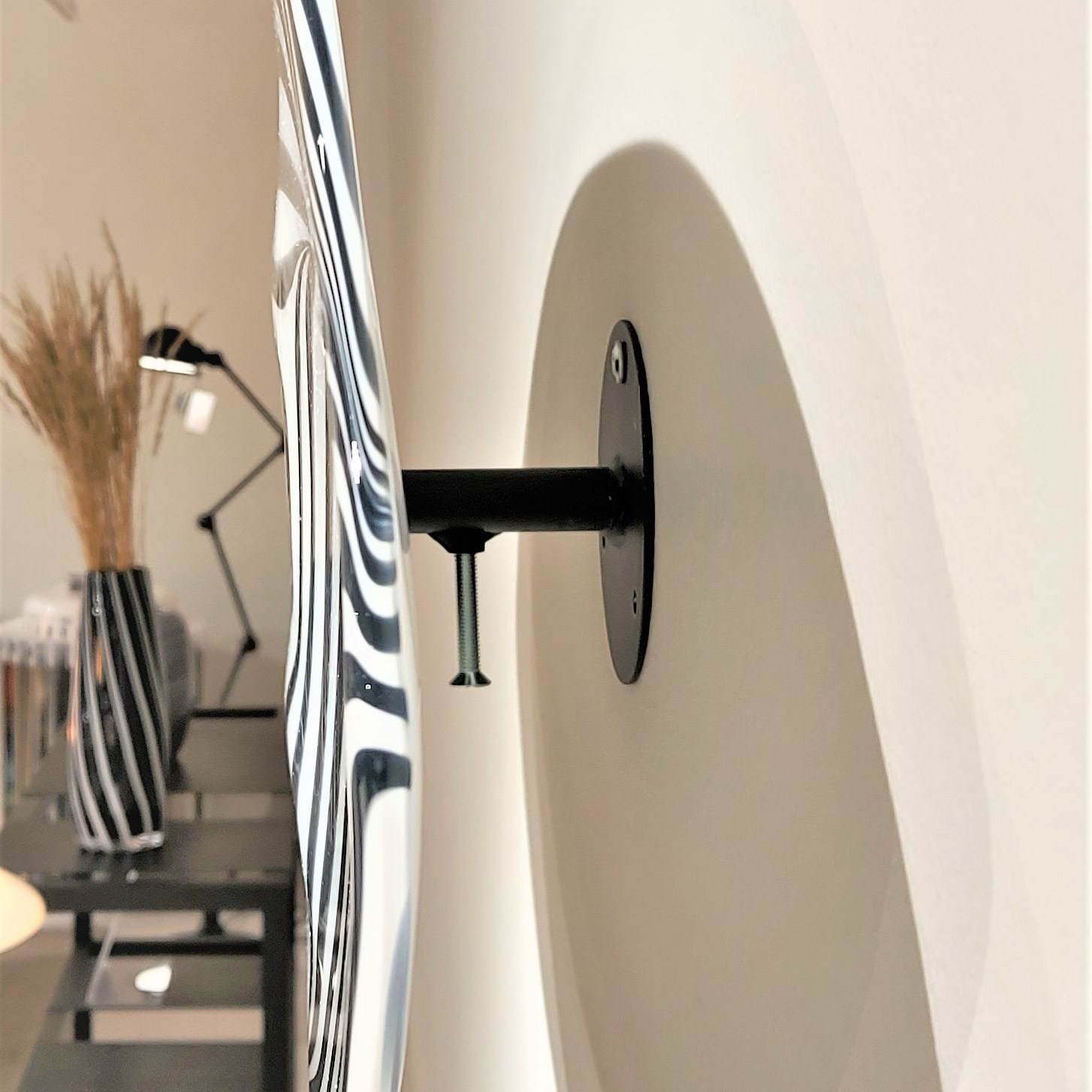 Veistoksen kiinnitys. Siipimäiset lasiteokset kiinnitetään seinään takaosassa olevan metallitelineen avulla. Heikki Jylhä-Vuorio.